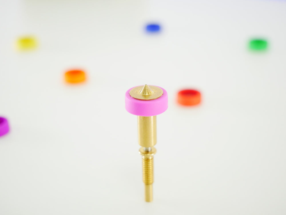 Close-up of an E3D Revo brass nozzle with pink 0.25 mm sock